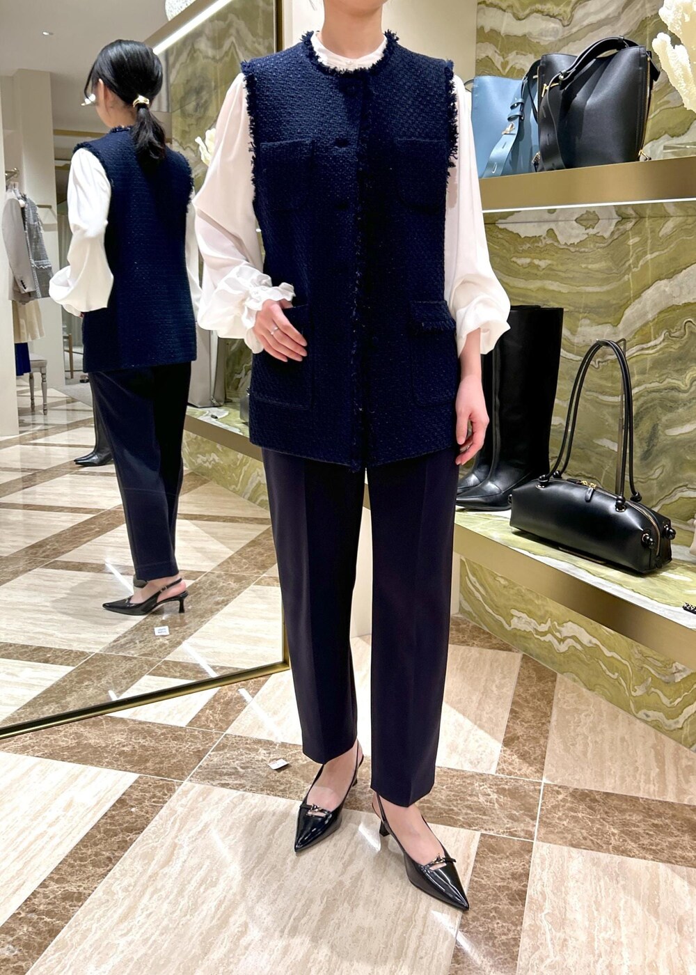 ブルー系のその他パンツ、ブラック系のパンプス、ブラック系のハンドバッグを着用したレディースの冬コーディネートの5枚目の写真