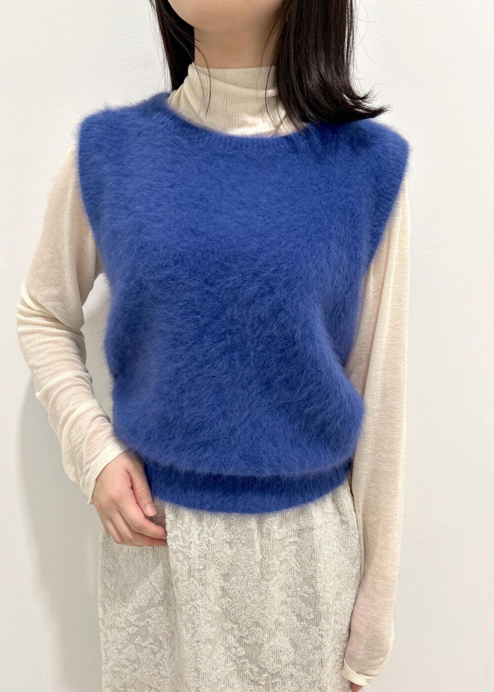 ブラック系のパンプス、ホワイト系のTシャツ/カットソー、ブルー系のベストを着用したレディースの秋コーディネートの5枚目の写真