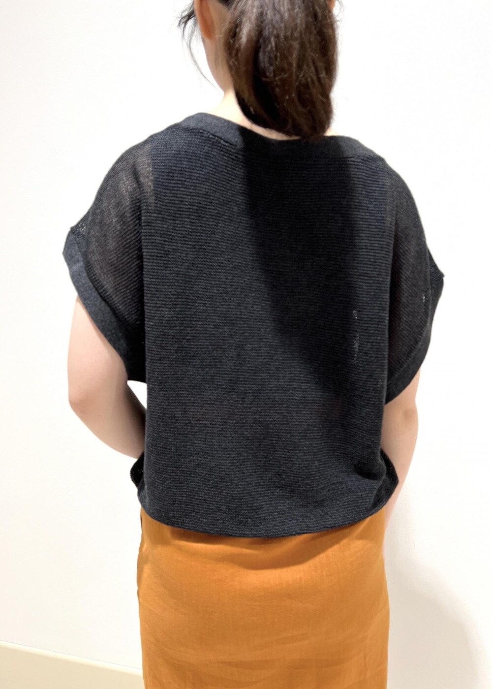 ホワイト系のハンドバッグ、ホワイト系のサンダル、オレンジ系のスカートを着用したレディースの夏コーディネートの6枚目の写真