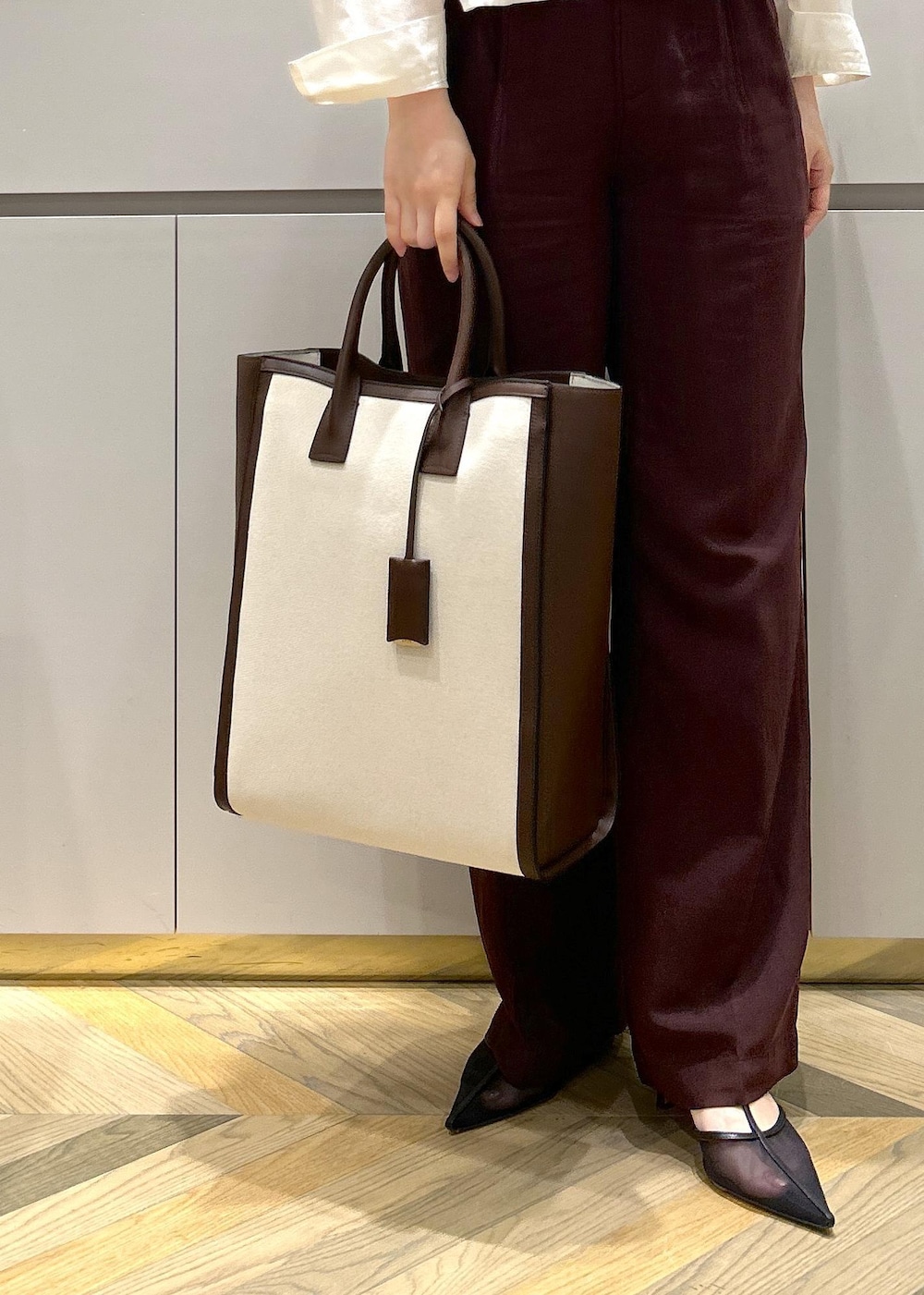 ブラウン系のトートバッグ、ホワイト系のシャツ/ブラウス、ブラック系のパンプスを着用したレディースの春コーディネートの8枚目の写真