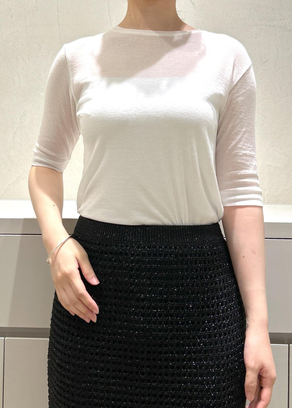 ホワイト系のハンドバッグ、ベージュ系のサンダル、ホワイト系のTシャツ/カットソーを着用したレディースの夏コーディネートの6枚目の写真