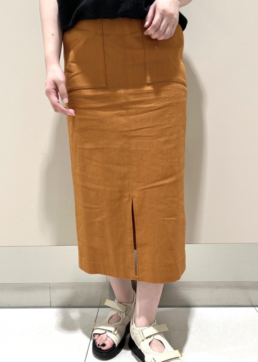 ホワイト系のハンドバッグ、ホワイト系のサンダル、オレンジ系のスカートを着用したレディースの夏コーディネートの7枚目の写真