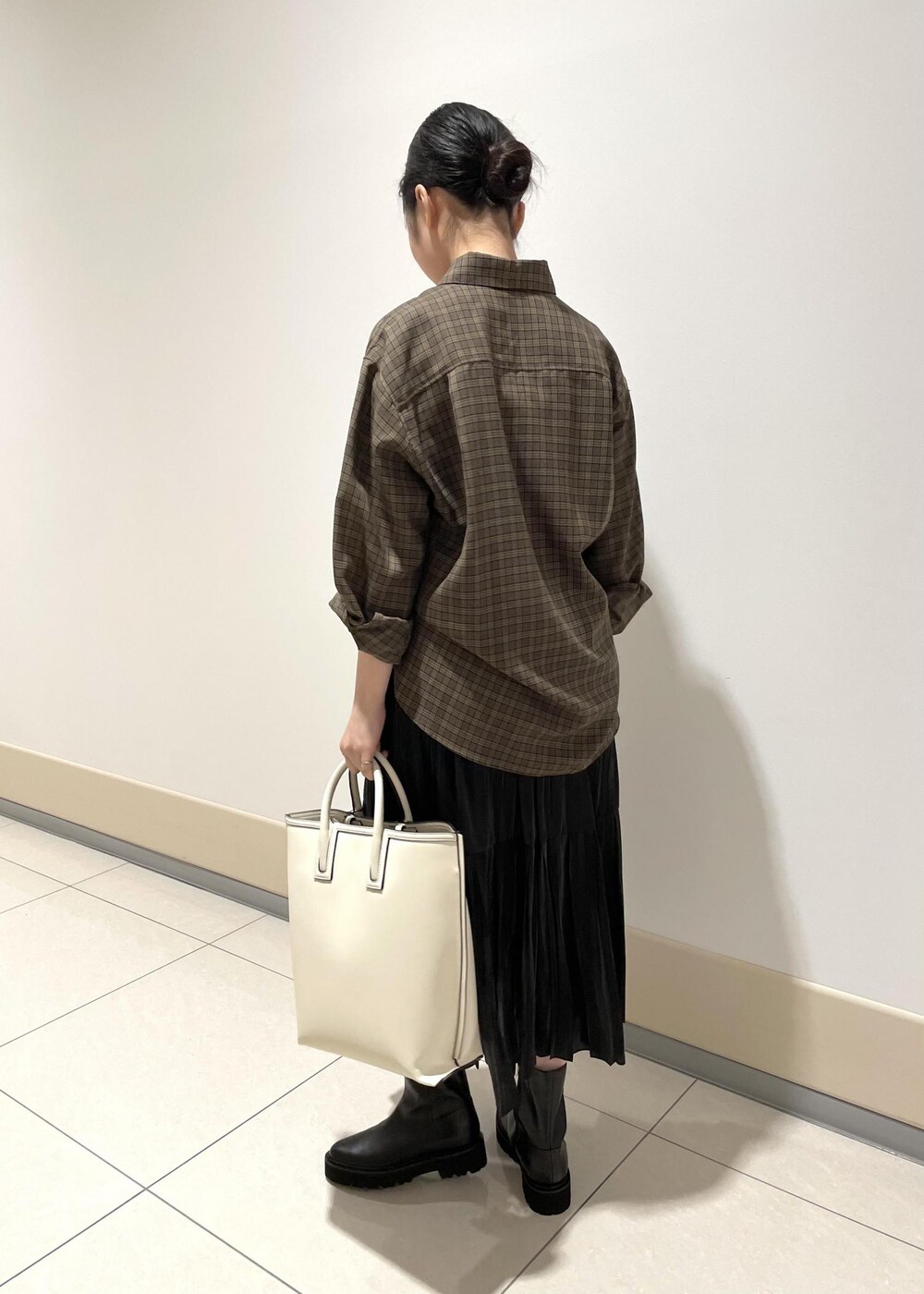 ホワイト系のトートバッグ、ベージュ系のシャツ/ブラウス、ブラック系のスカートを着用したレディースの秋コーディネートの3枚目の写真