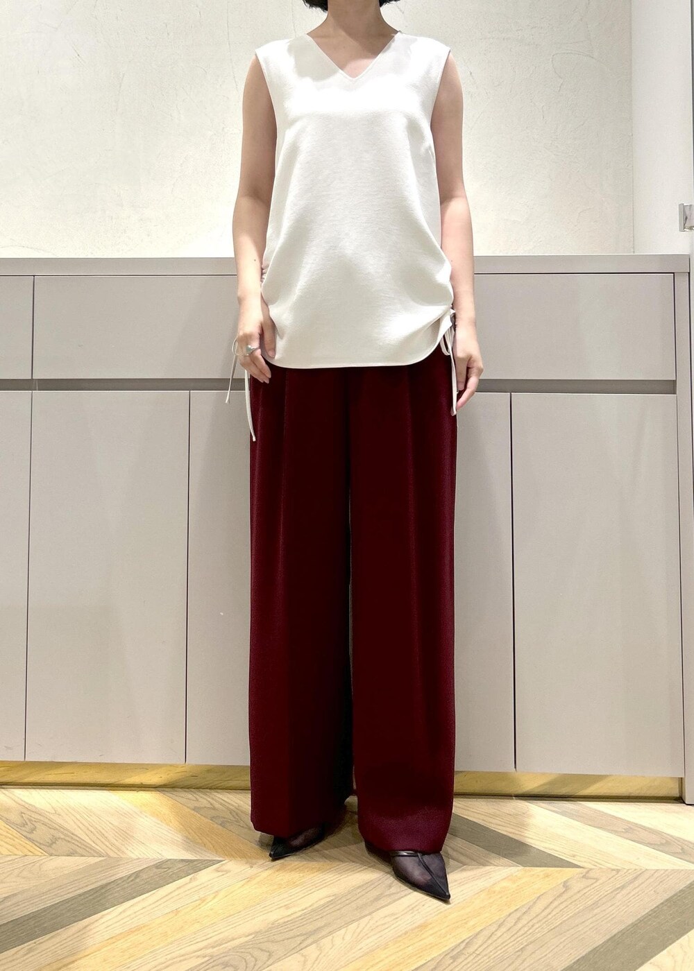 ホワイト系のトートバッグ、ブラック系のパンプス、レッド系のその他パンツを着用したレディースの夏コーディネートの4枚目の写真