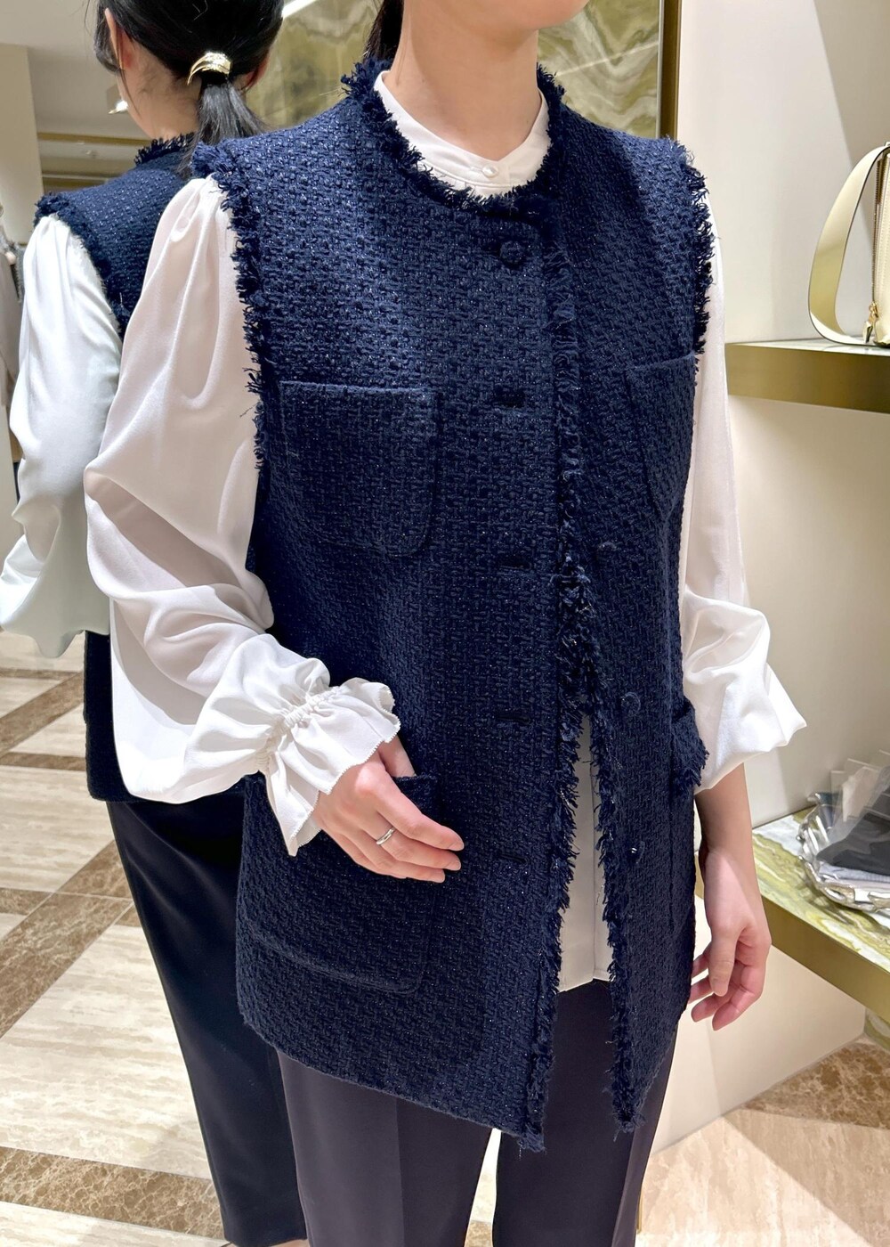 ブルー系のその他パンツ、ブラック系のパンプス、ブラック系のハンドバッグを着用したレディースの冬コーディネートの6枚目の写真