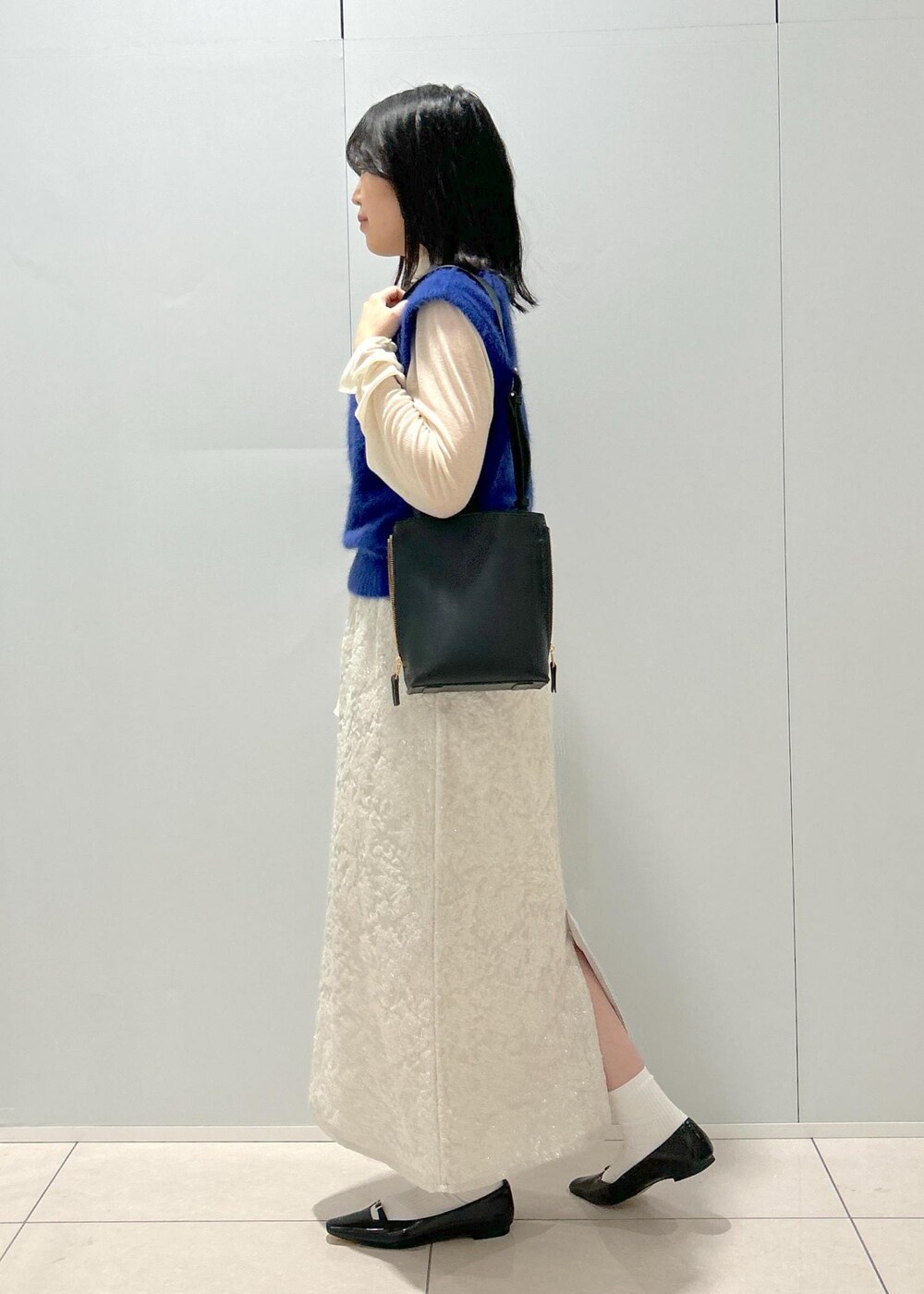 ブラック系のパンプス、ホワイト系のTシャツ/カットソー、ブルー系のベストを着用したレディースの秋コーディネートの2枚目の写真