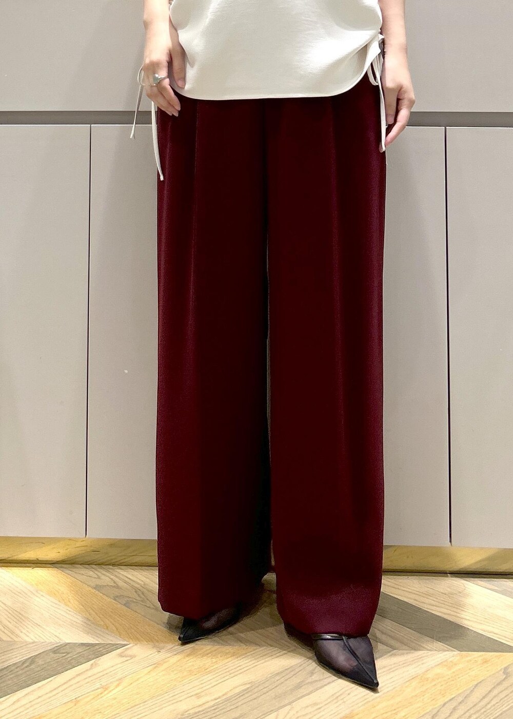 ホワイト系のトートバッグ、ブラック系のパンプス、レッド系のその他パンツを着用したレディースの夏コーディネートの6枚目の写真