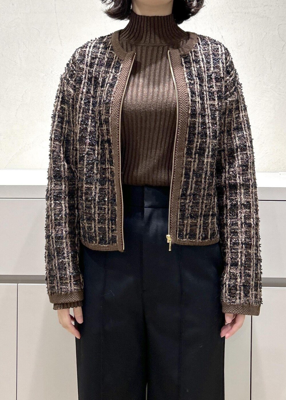 グレー系のショルダーバッグ、ブラウン系のニット/セーター、ブラック系のその他パンツを着用したレディースの秋コーディネートの5枚目の写真