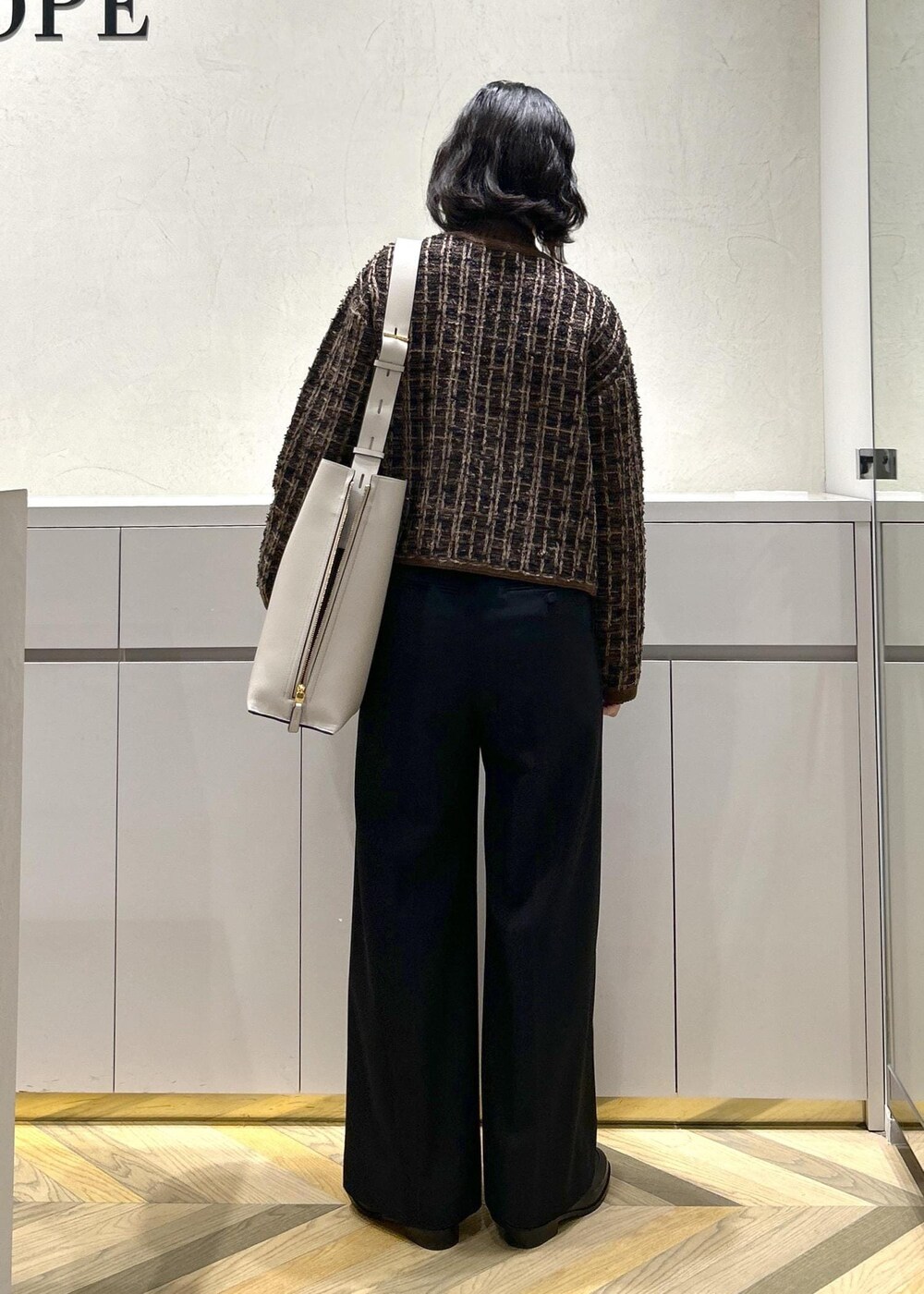 グレー系のショルダーバッグ、ブラウン系のニット/セーター、ブラック系のその他パンツを着用したレディースの秋コーディネートの3枚目の写真