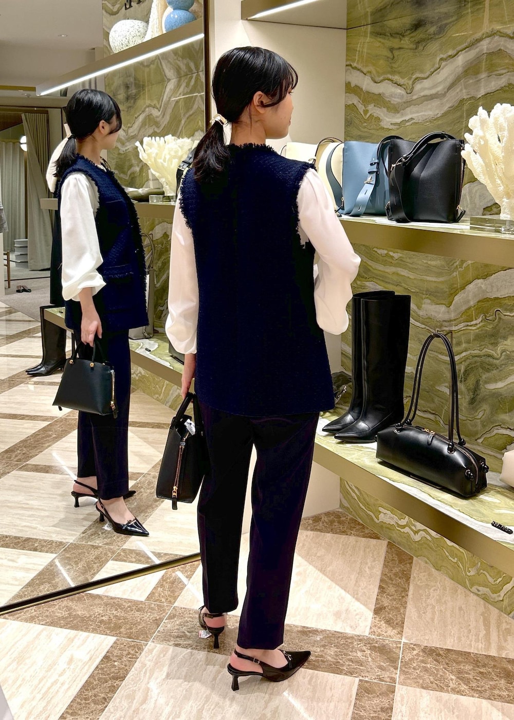 ブルー系のその他パンツ、ブラック系のパンプス、ブラック系のハンドバッグを着用したレディースの冬コーディネートの4枚目の写真