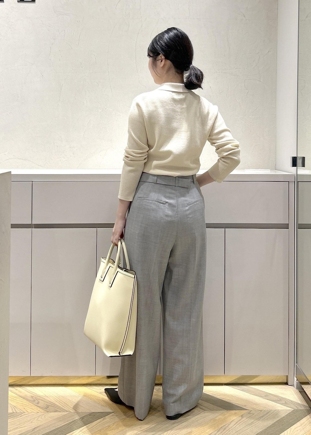 ブラック系のパンプス、ホワイト系のトートバッグ、グレー系のその他パンツを着用したレディースの冬コーディネートの3枚目の写真