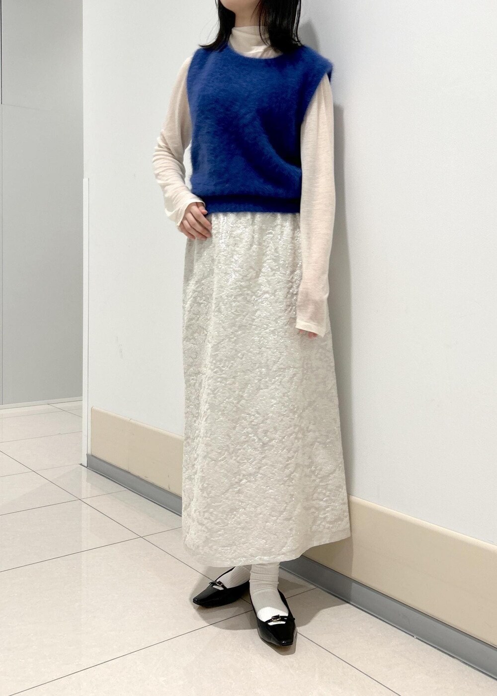 ブラック系のパンプス、ホワイト系のTシャツ/カットソー、ブルー系のベストを着用したレディースの秋コーディネートの4枚目の写真