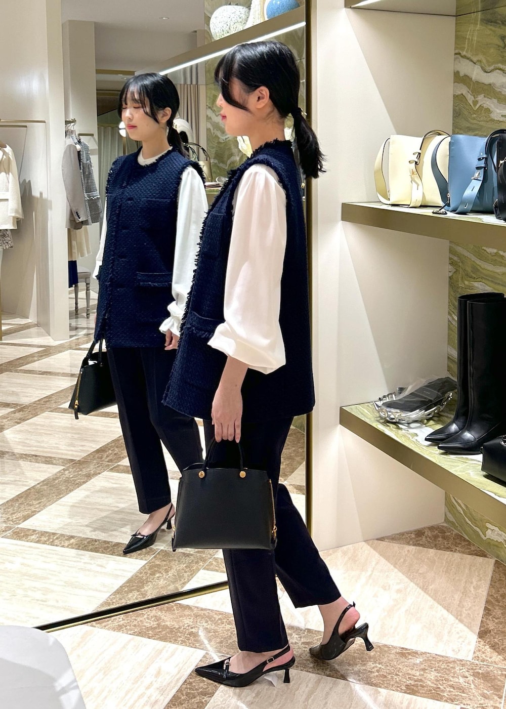 ブルー系のその他パンツ、ブラック系のパンプス、ブラック系のハンドバッグを着用したレディースの冬コーディネートの3枚目の写真