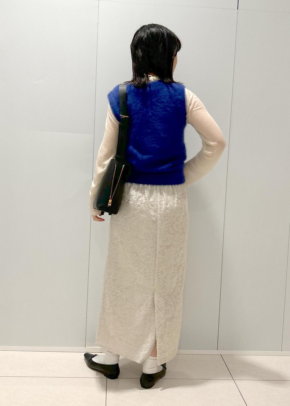 ブラック系のパンプス、ホワイト系のTシャツ/カットソー、ブルー系のベストを着用したレディースの秋コーディネートの3枚目の写真