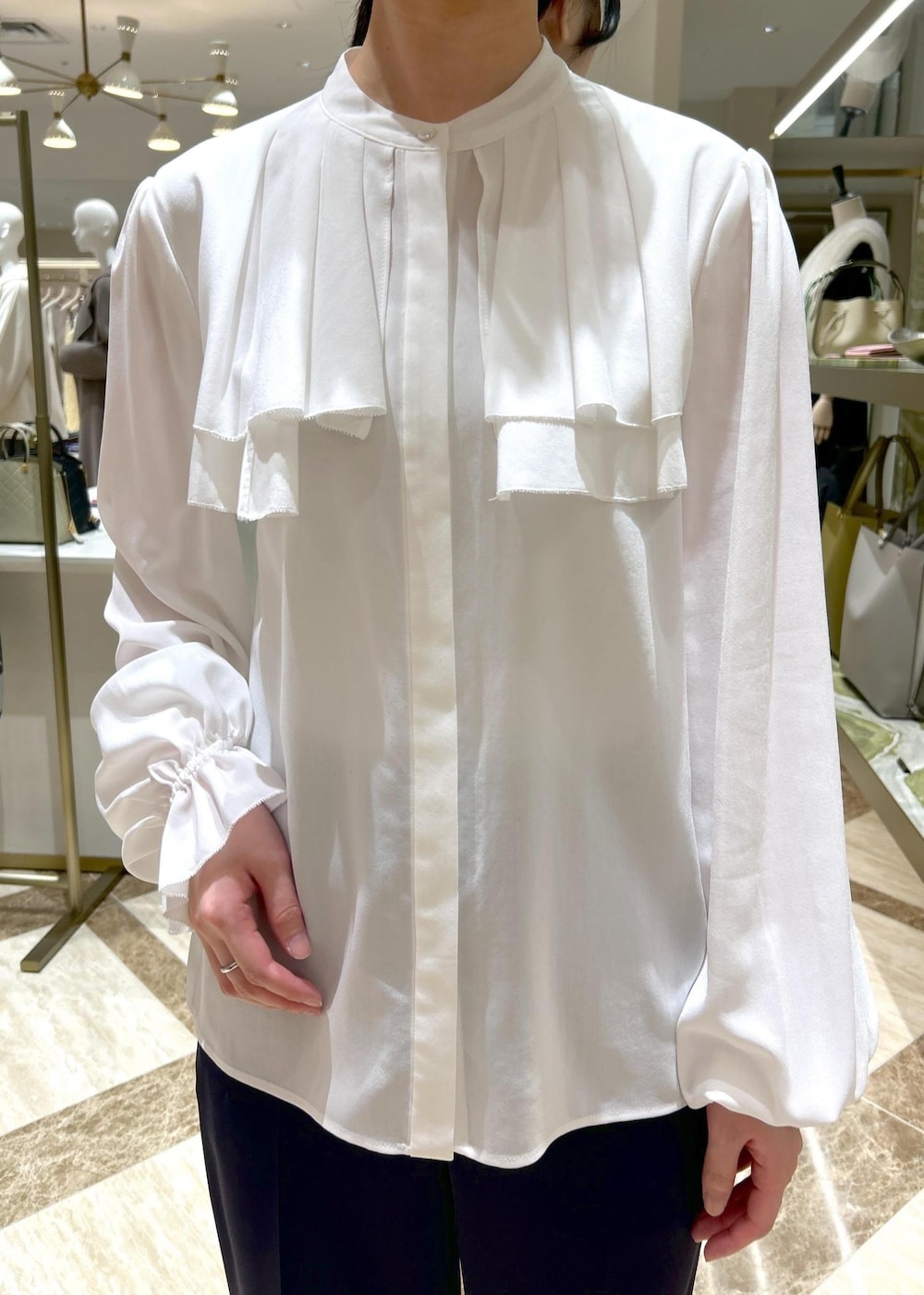 ブルー系のその他パンツ、ブラック系のパンプス、ブラック系のハンドバッグを着用したレディースの冬コーディネートの8枚目の写真