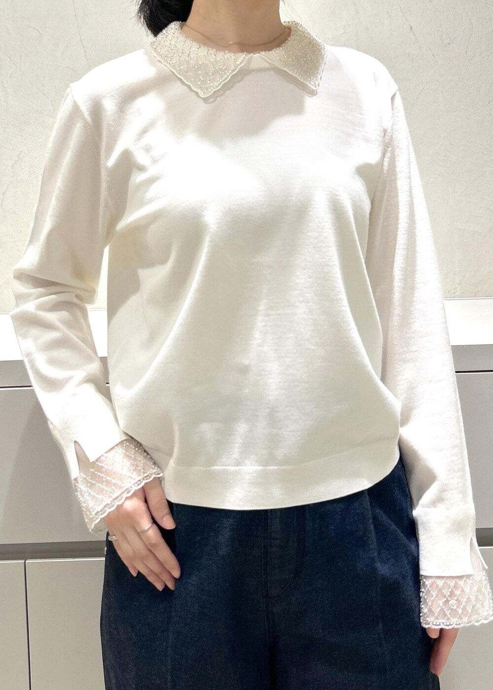 ブラック系のパンプス、ホワイト系のトートバッグ、ブルー系のデニムパンツを着用したレディースの冬コーディネートの5枚目の写真