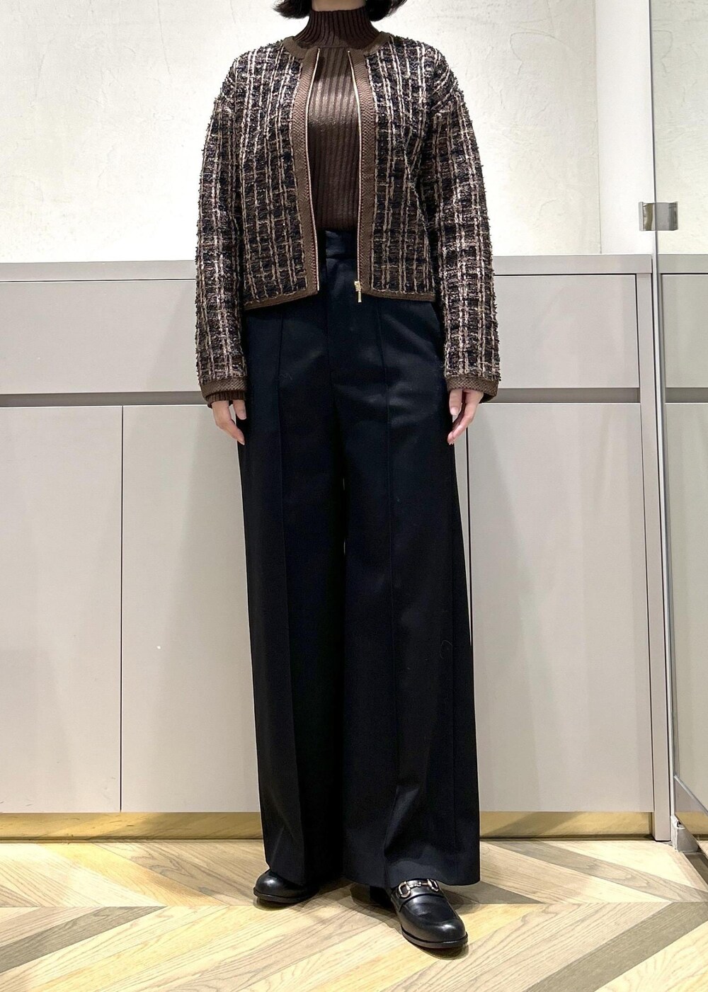 グレー系のショルダーバッグ、ブラウン系のニット/セーター、ブラック系のその他パンツを着用したレディースの秋コーディネートの4枚目の写真