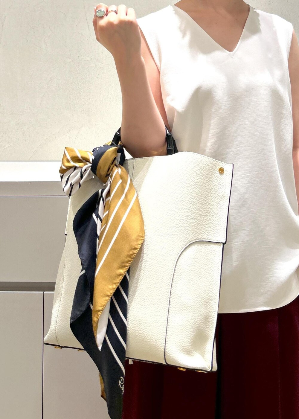 ホワイト系のトートバッグ、ブラック系のパンプス、レッド系のその他パンツを着用したレディースの夏コーディネートの7枚目の写真