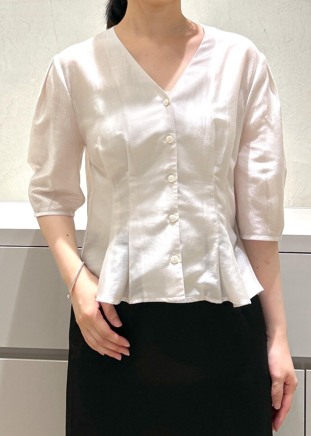 ブラック系のパンプス、ベージュ系のトートバッグ、ブラック系のスカートを着用したレディースの夏コーディネートの5枚目の写真