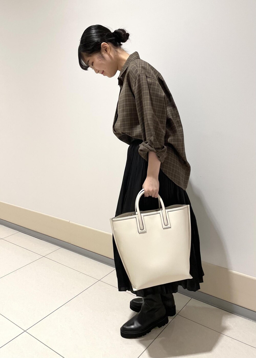 ホワイト系のトートバッグ、ベージュ系のシャツ/ブラウス、ブラック系のスカートを着用したレディースの秋コーディネートの2枚目の写真