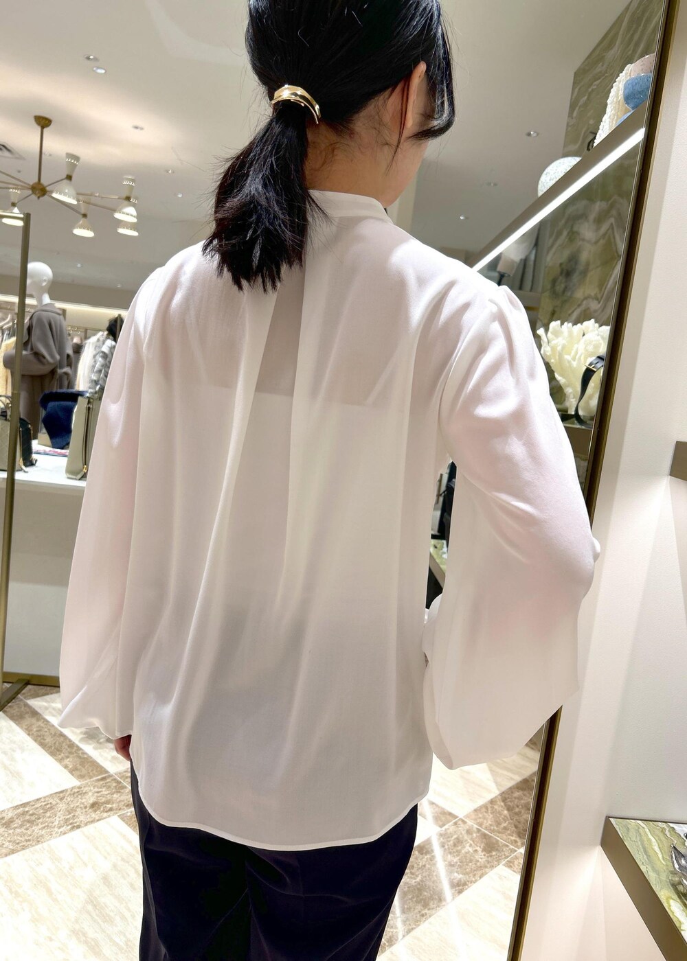 ブルー系のその他パンツ、ブラック系のパンプス、ブラック系のハンドバッグを着用したレディースの冬コーディネートの10枚目の写真