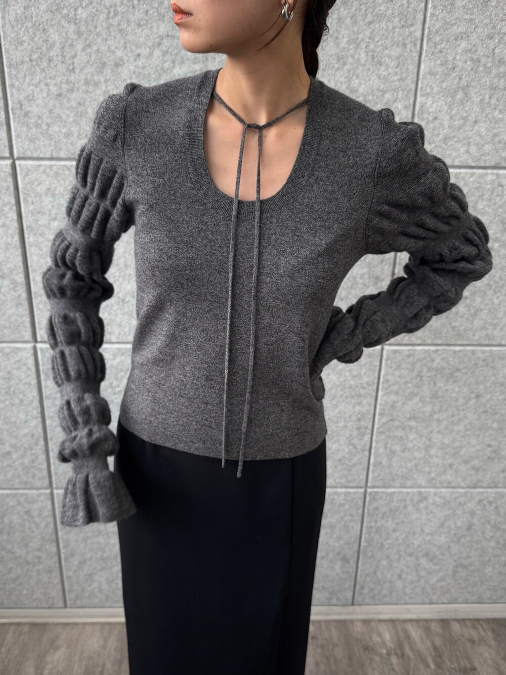 ブラック系のスカート、グレー系のニット/セーターを着用したレディースの冬コーディネートの4枚目の写真