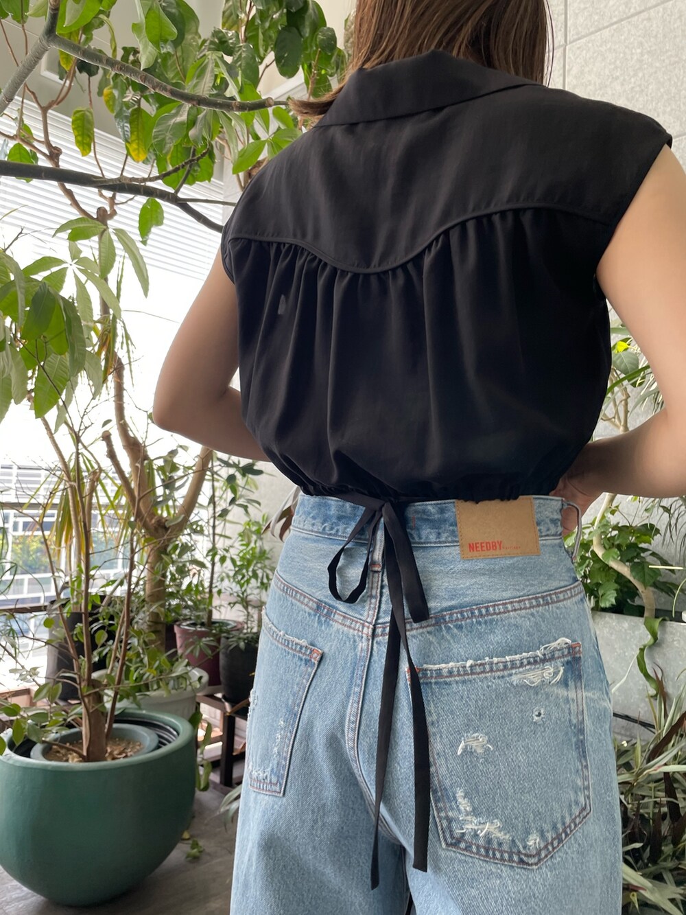 ブルー系のデニムパンツ、ブラック系のシャツ/ブラウスを着用したレディースの夏コーディネートの4枚目の写真