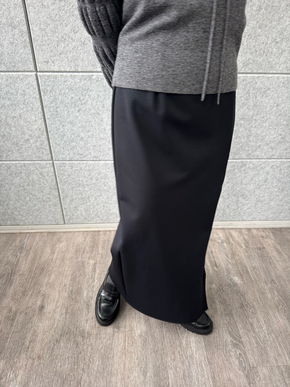 ブラック系のスカート、グレー系のニット/セーターを着用したレディースの冬コーディネートの6枚目の写真