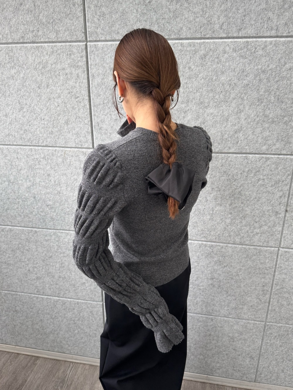 ブラック系のスカート、グレー系のニット/セーターを着用したレディースの冬コーディネートの7枚目の写真