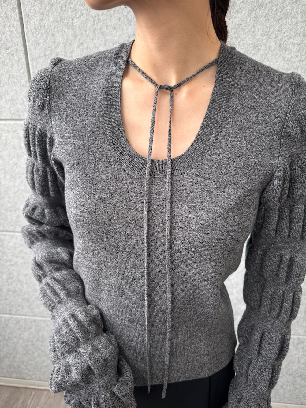 ブラック系のスカート、グレー系のニット/セーターを着用したレディースの冬コーディネートの5枚目の写真