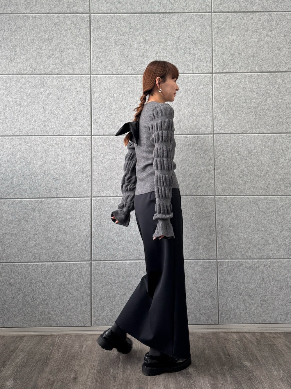 ブラック系のスカート、グレー系のニット/セーターを着用したレディースの冬コーディネートの2枚目の写真