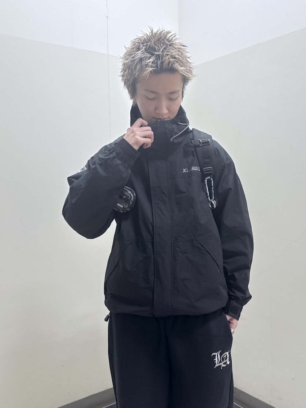 ブラック系のナイロンジャケット、ブラック系のバックパック/リュック、ブラック系のスウェットパンツを着用したメンズの冬コーディネートの9枚目の写真