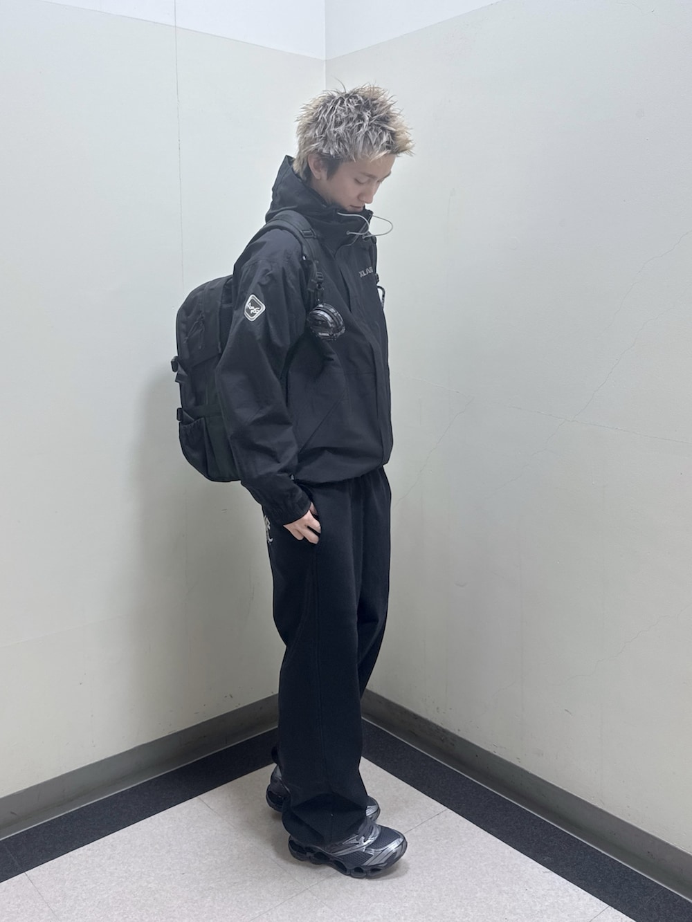 ブラック系のナイロンジャケット、ブラック系のバックパック/リュック、ブラック系のスウェットパンツを着用したメンズの冬コーディネートの8枚目の写真