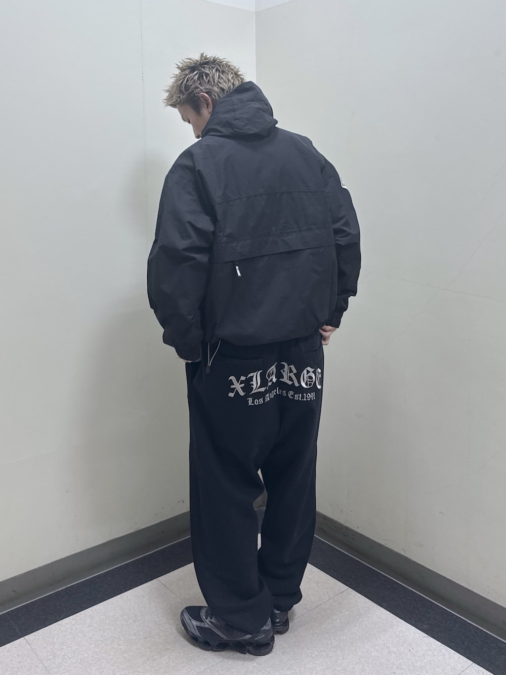 ブラック系のナイロンジャケット、ブラック系のバックパック/リュック、ブラック系のスウェットパンツを着用したメンズの冬コーディネートの5枚目の写真