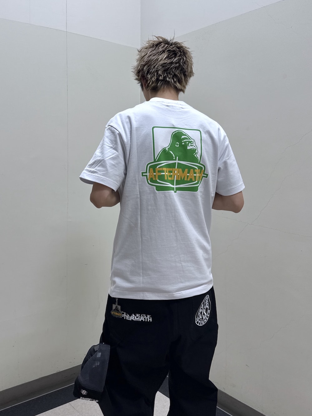 ブラック系のその他アウター、ホワイト系のTシャツ/カットソー、ブラック系のその他パンツを着用したメンズの冬コーディネートの4枚目の写真