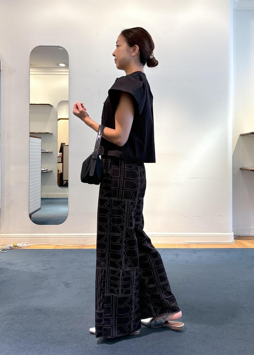 ブラック系のその他パンツ、シルバー系のパンプス、ブラック系のハンドバッグを着用したレディースの夏コーディネートの2枚目の写真