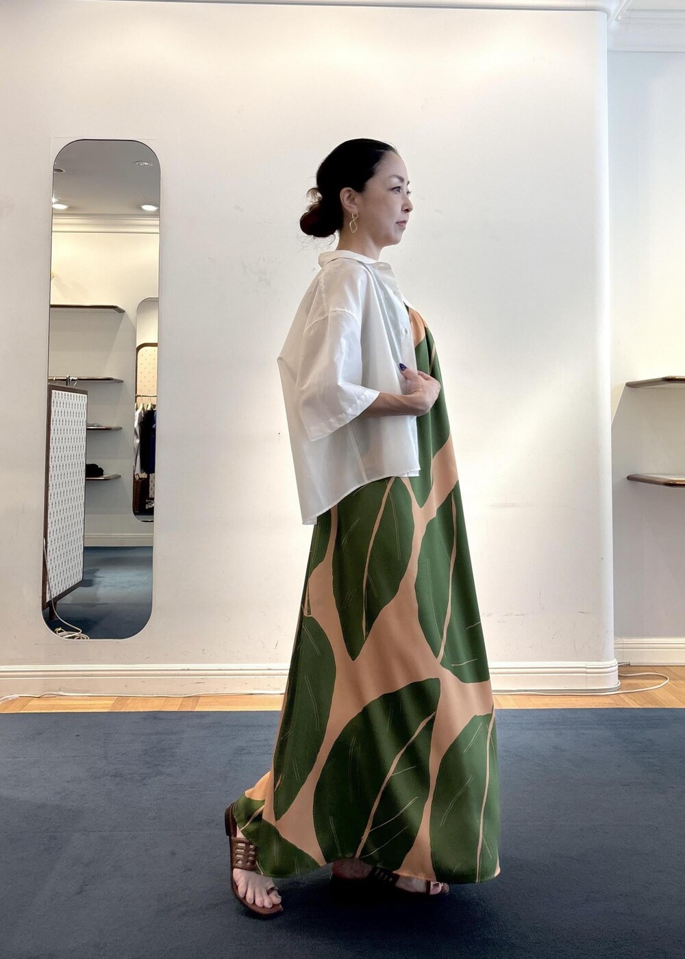 グリーン系のワンピース、ブラウン系のニット/セーター、ホワイト系のシャツ/ブラウスを着用したレディースの夏コーディネートの4枚目の写真