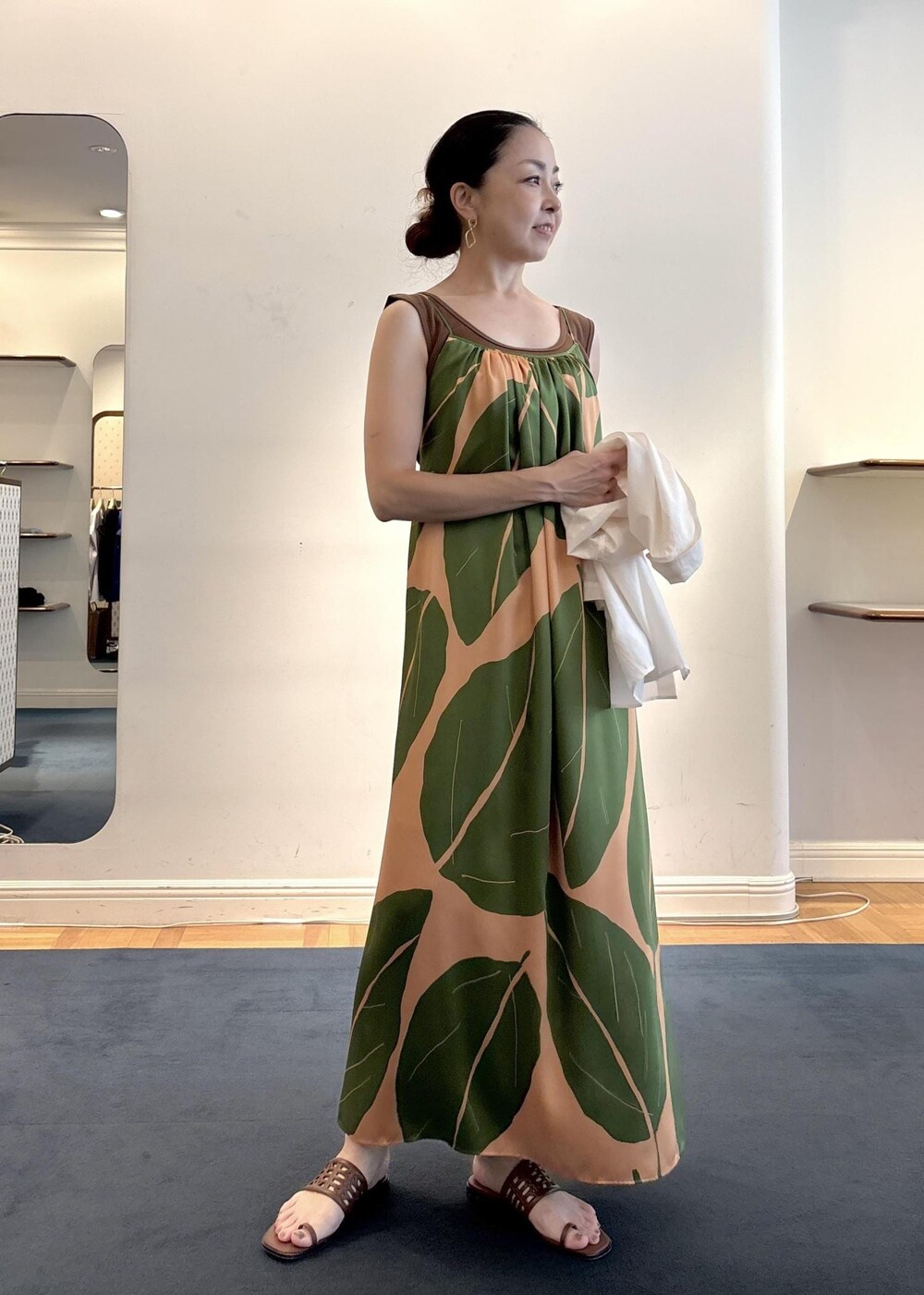 グリーン系のワンピース、ブラウン系のニット/セーター、ホワイト系のシャツ/ブラウスを着用したレディースの夏コーディネートの6枚目の写真