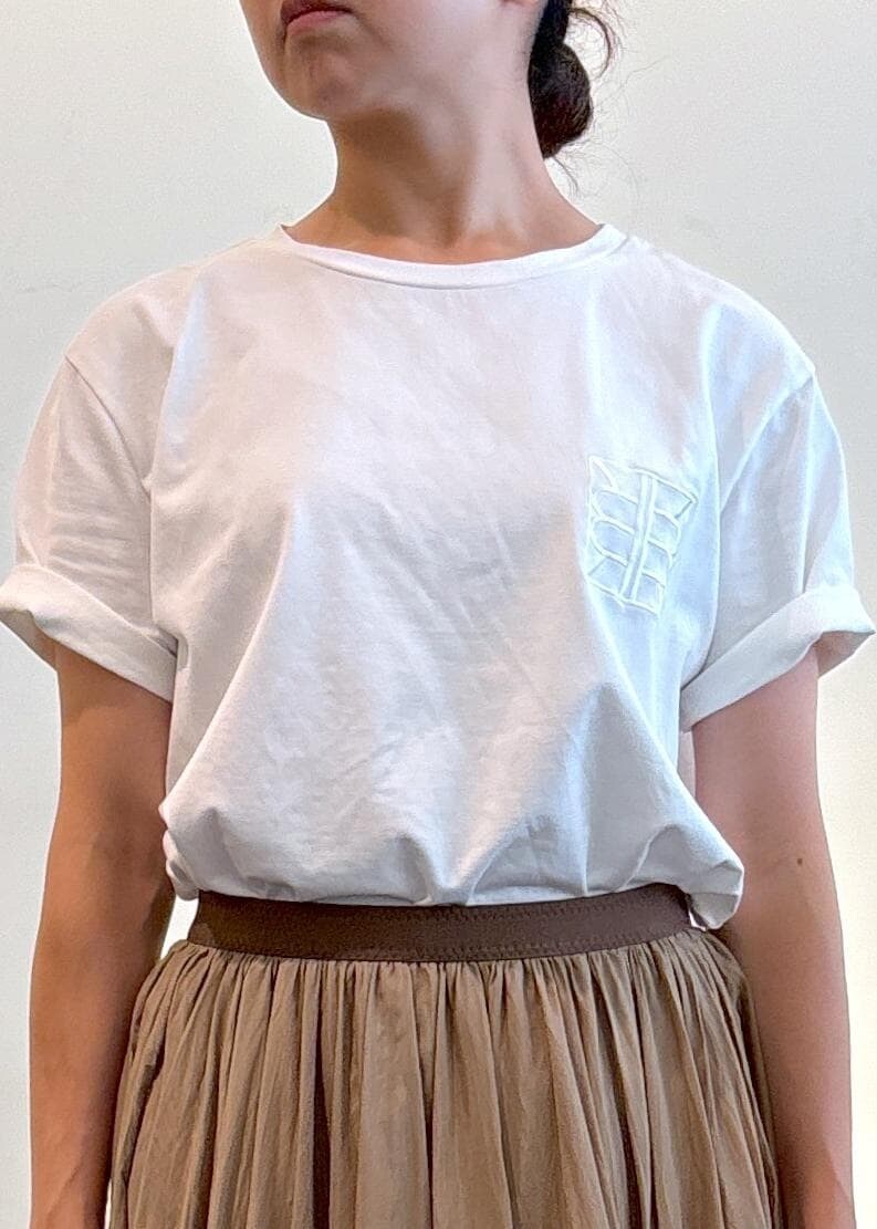 ベージュ系のトートバッグ、ブラック系のサンダル、ホワイト系のTシャツ/カットソーを着用したレディースの夏コーディネートの5枚目の写真