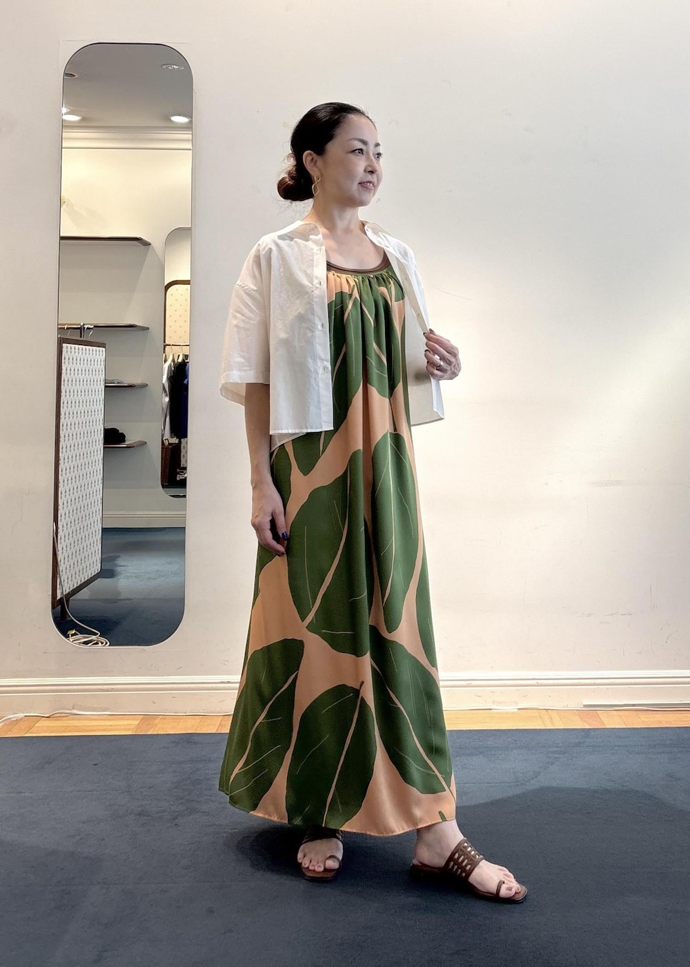 グリーン系のワンピース、ブラウン系のニット/セーター、ホワイト系のシャツ/ブラウスを着用したレディースの夏コーディネートの2枚目の写真