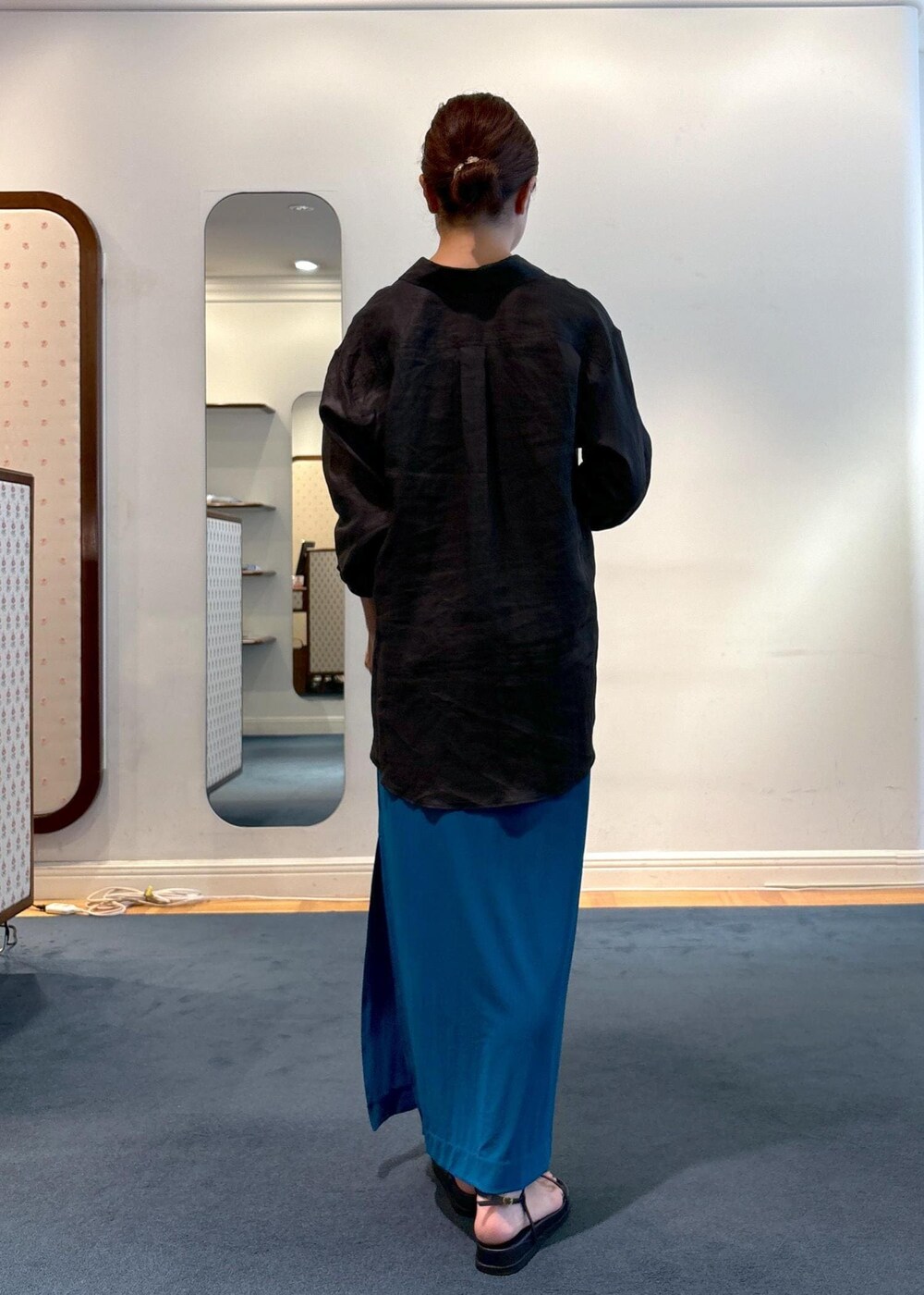 ブラック系のシャツ/ブラウス、ブラック系のサンダル、ブルー系のスカートを着用したレディースの夏コーディネートの3枚目の写真