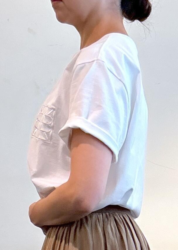 ベージュ系のトートバッグ、ブラック系のサンダル、ホワイト系のTシャツ/カットソーを着用したレディースの夏コーディネートの6枚目の写真