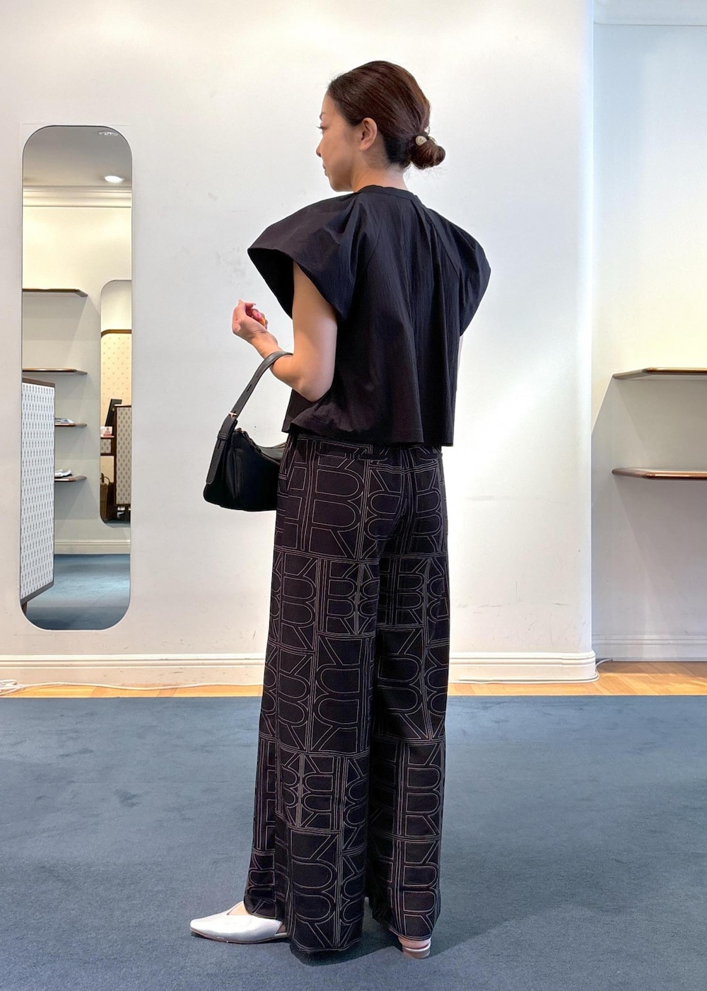 ブラック系のその他パンツ、シルバー系のパンプス、ブラック系のハンドバッグを着用したレディースの夏コーディネートの3枚目の写真