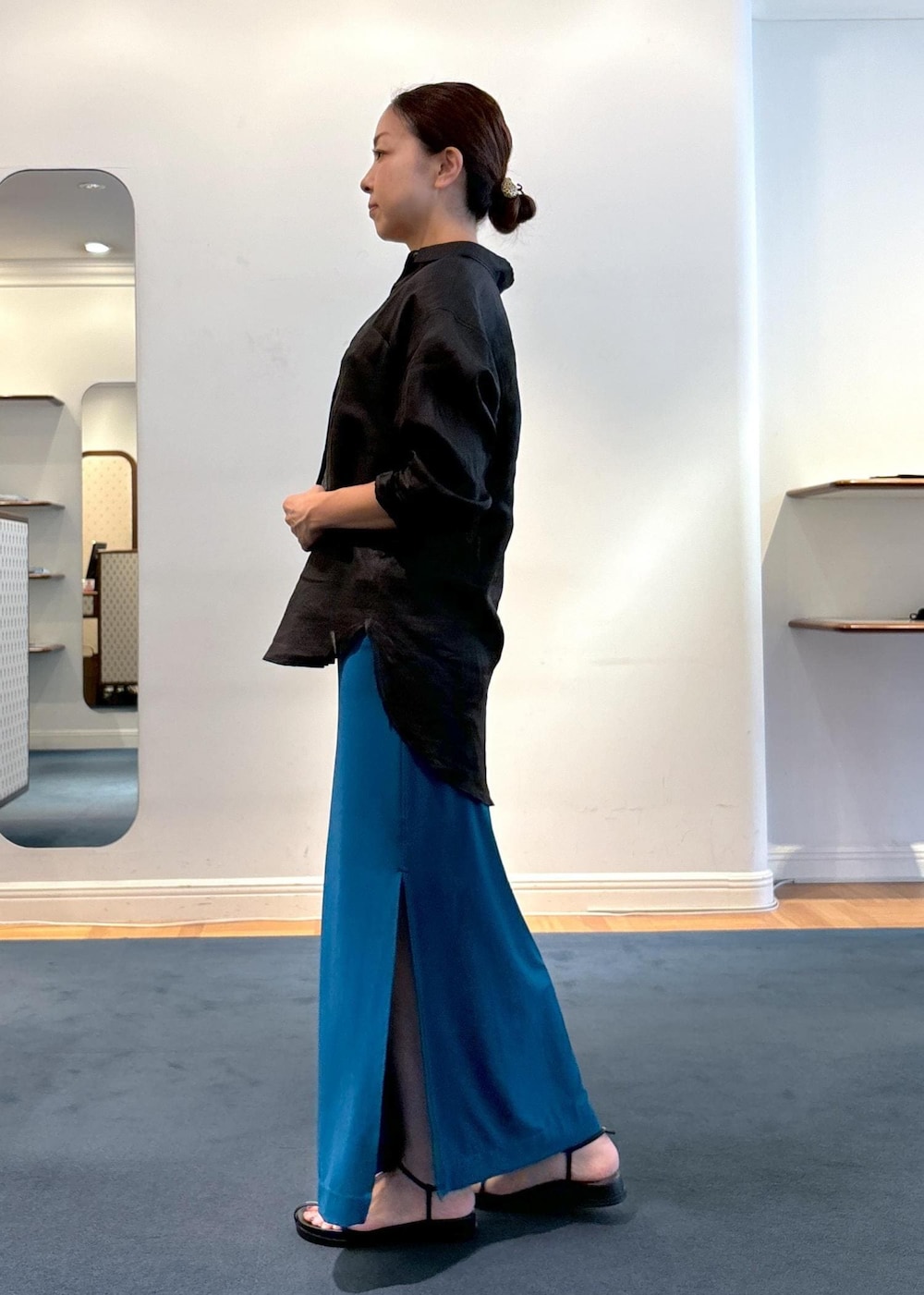 ブラック系のシャツ/ブラウス、ブラック系のサンダル、ブルー系のスカートを着用したレディースの夏コーディネートの2枚目の写真