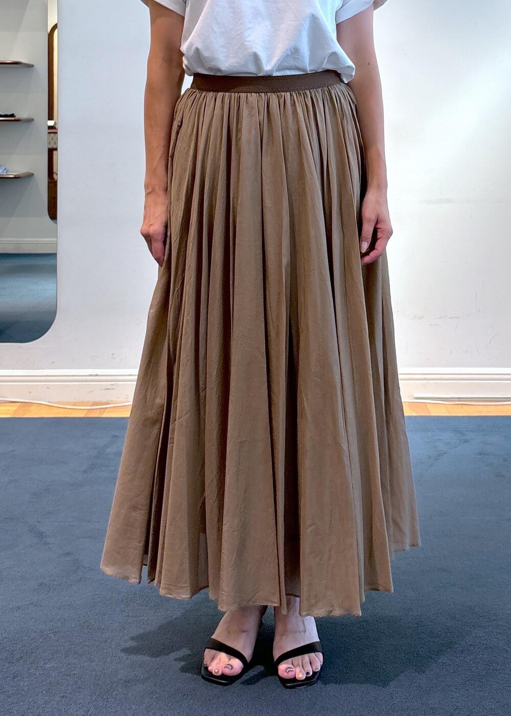 ベージュ系のトートバッグ、ブラック系のサンダル、ホワイト系のTシャツ/カットソーを着用したレディースの夏コーディネートの7枚目の写真