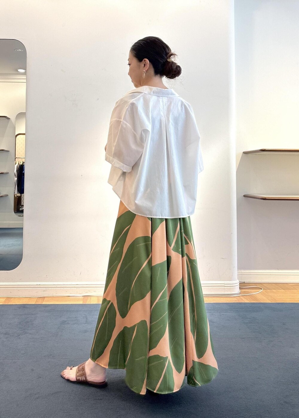 グリーン系のワンピース、ブラウン系のニット/セーター、ホワイト系のシャツ/ブラウスを着用したレディースの夏コーディネートの3枚目の写真