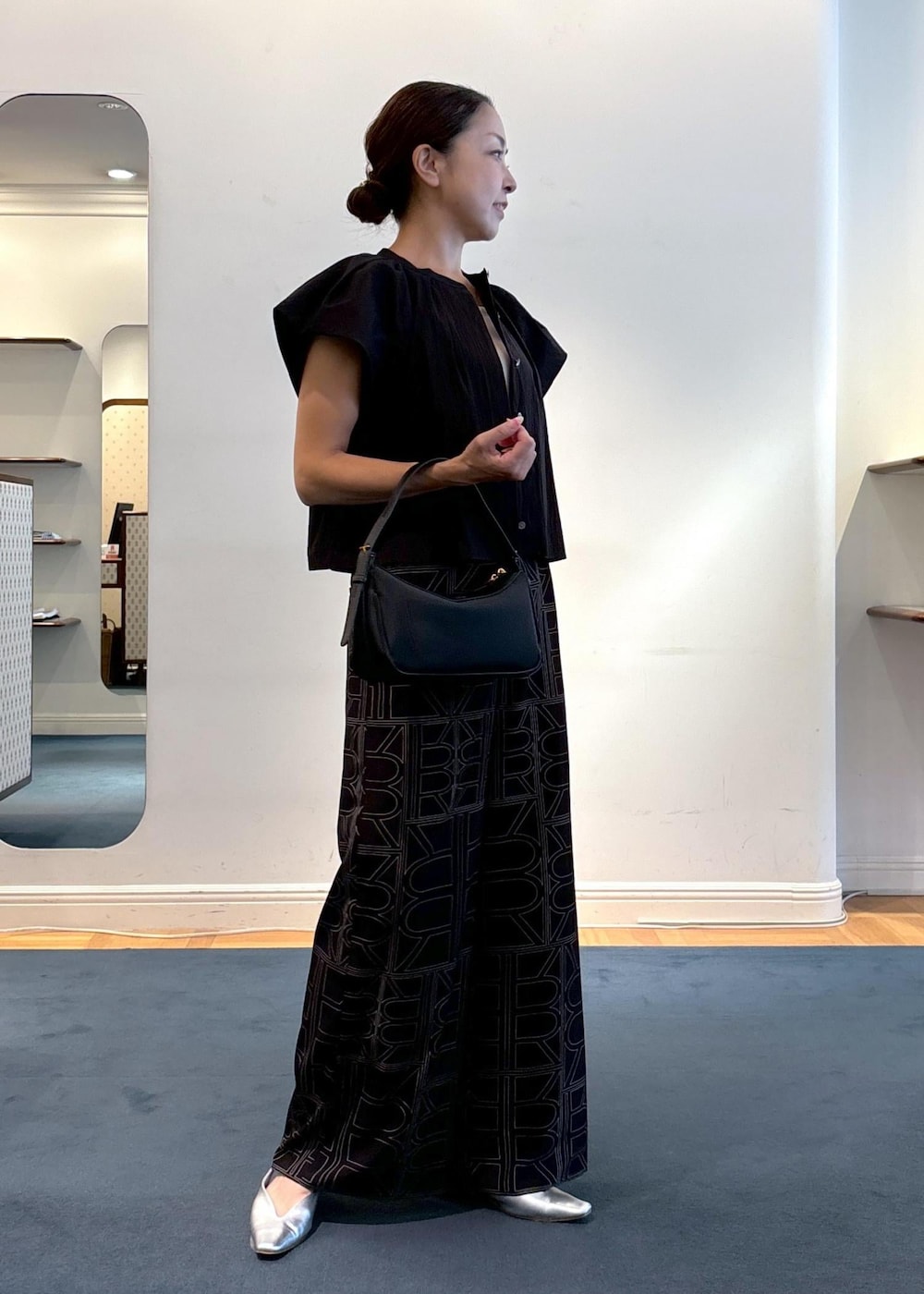 ブラック系のその他パンツ、シルバー系のパンプス、ブラック系のハンドバッグを着用したレディースの夏コーディネートの4枚目の写真