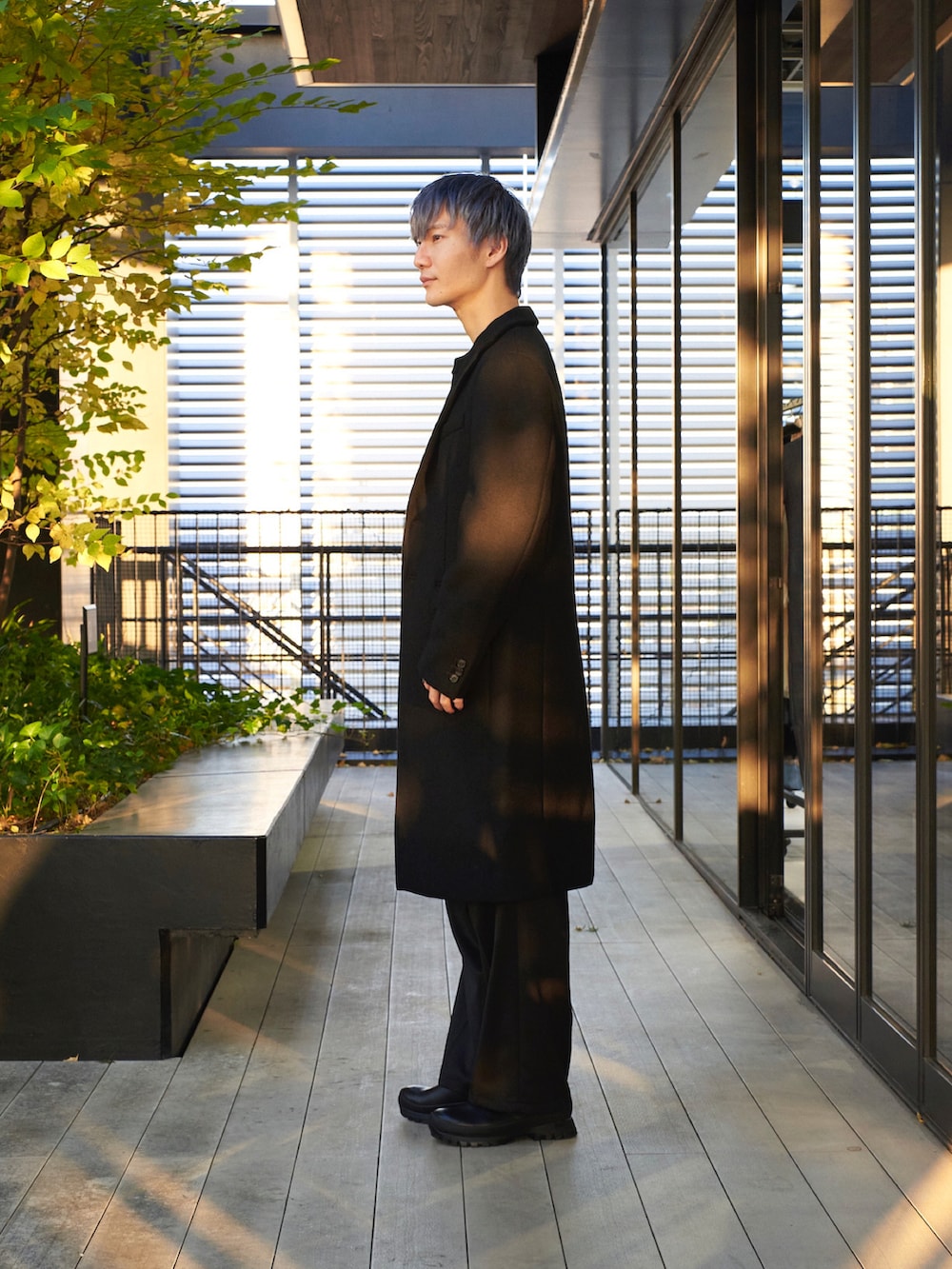 ブラック系のチェスターコートを着用したメンズの秋コーディネートの2枚目の写真