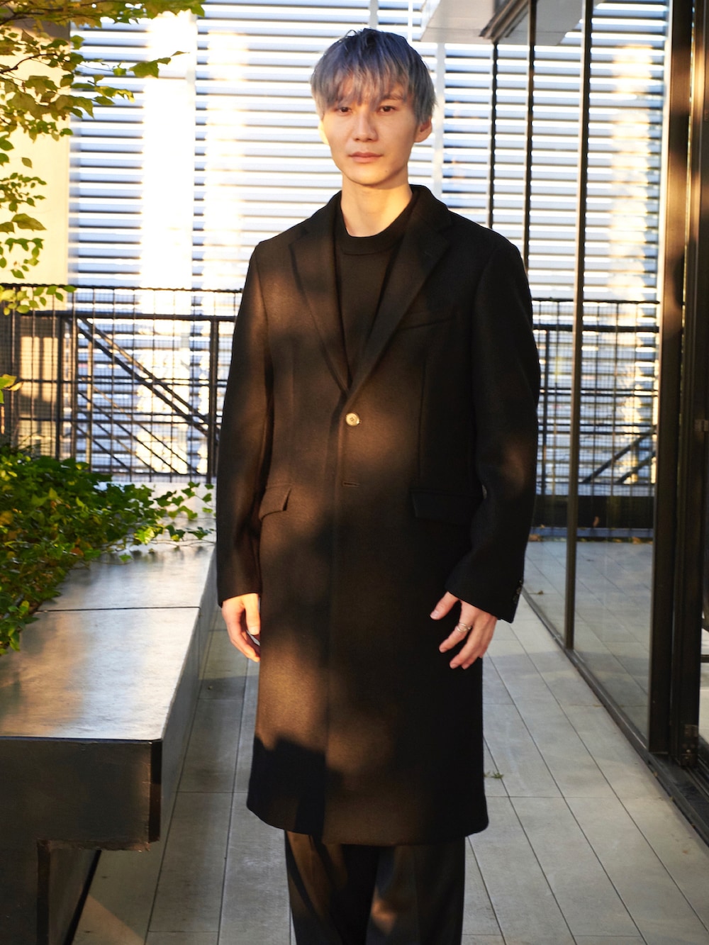 ブラック系のチェスターコートを着用したメンズの秋コーディネートの4枚目の写真