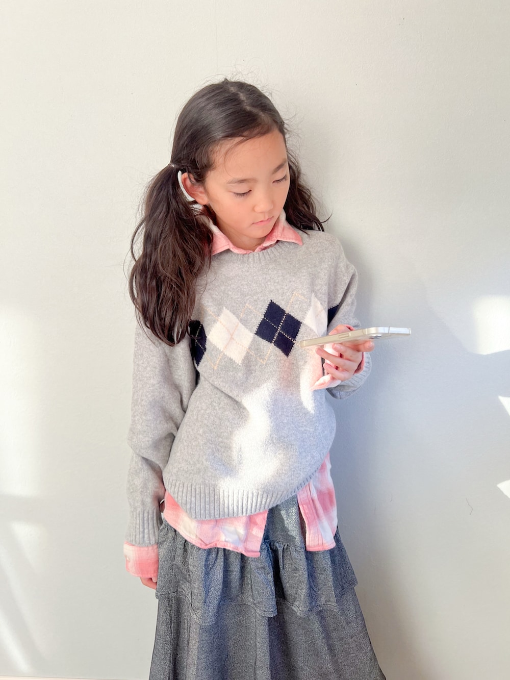 ブラック系のスカート、グレー系のニット/セーターを着用したキッズの秋コーディネートの3枚目の写真
